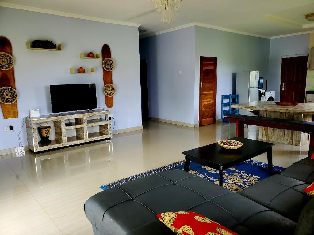 a living room with a couch and a tv at Sweet Retreat-1 in Lusaka