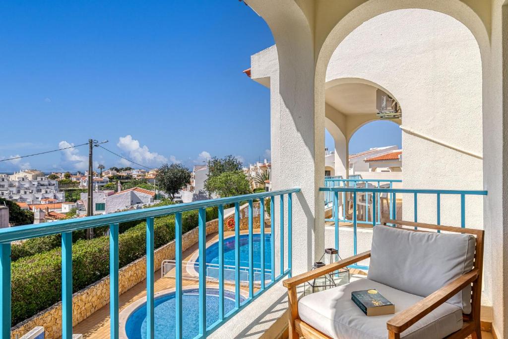 einen Balkon mit einem Stuhl und einem Pool in der Unterkunft Carvoeiro -Spacious 2 bedroom appartment with pool - Monte Dourado in Carvoeiro