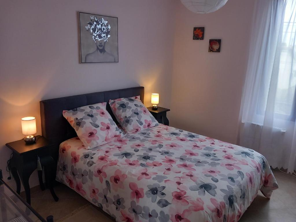 - une chambre avec un lit avec un couvre-lit floral et deux lampes dans l'établissement Jolie F2 à 5mn de l'aéroport d'Orly, à Paray-Vieille-Poste