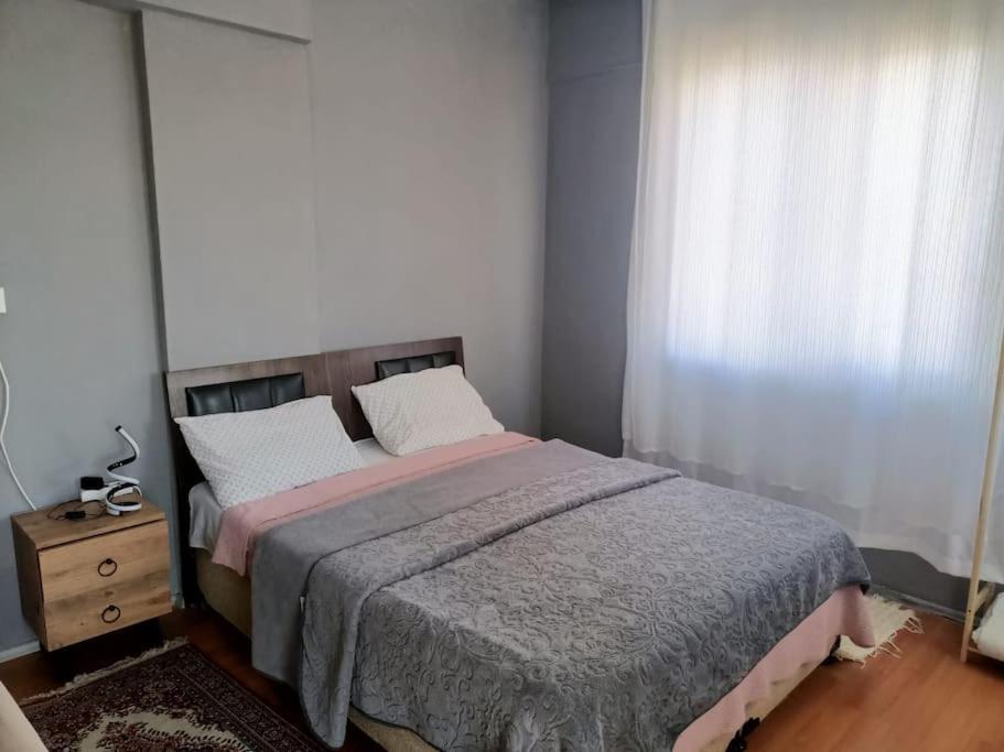 ein Schlafzimmer mit einem großen Bett und einem Fenster in der Unterkunft 3+1 daire.hızlı Wifi,havalimanı plaj, market yakın in Antalya
