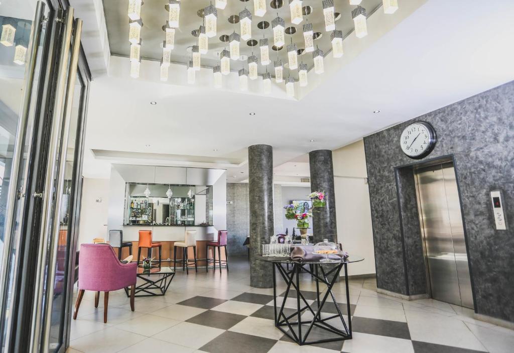 a dining room and living room with a clock on the wall at Le Fred in Antananarivo