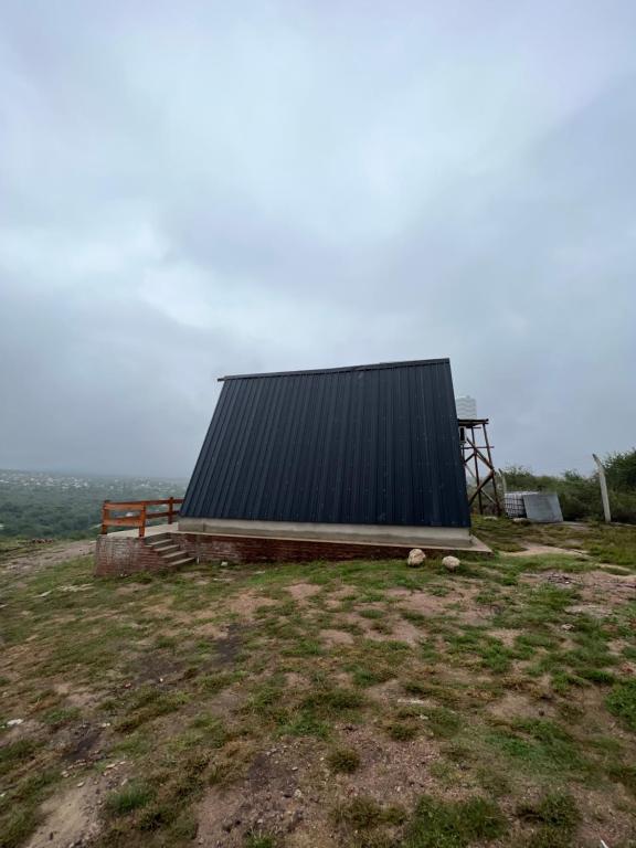 un edificio sentado en lo alto de un campo de césped en Cabañas alpinas del mirador en Bialet Massé