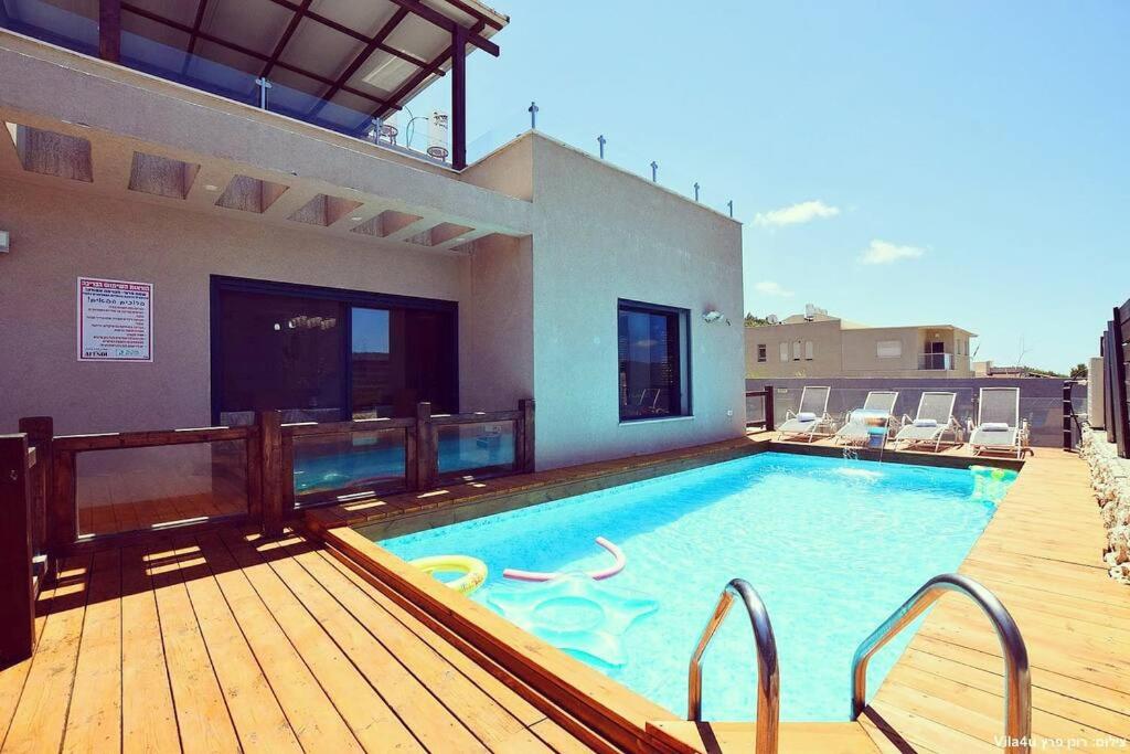 una gran piscina en una terraza junto a una casa en אחוזת אפנדי, en Ya‘ara