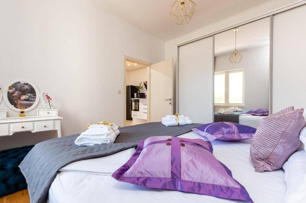 a bedroom with two beds with purple pillows on them at Luxa 5 min old town, 10 min airport in Trogir