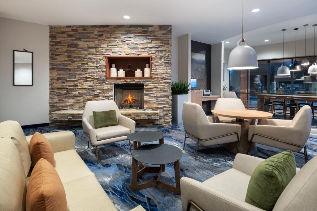 a lobby with couches and chairs and a fireplace at Fairfield Inn & Suites Orlando Ocoee in Orlando