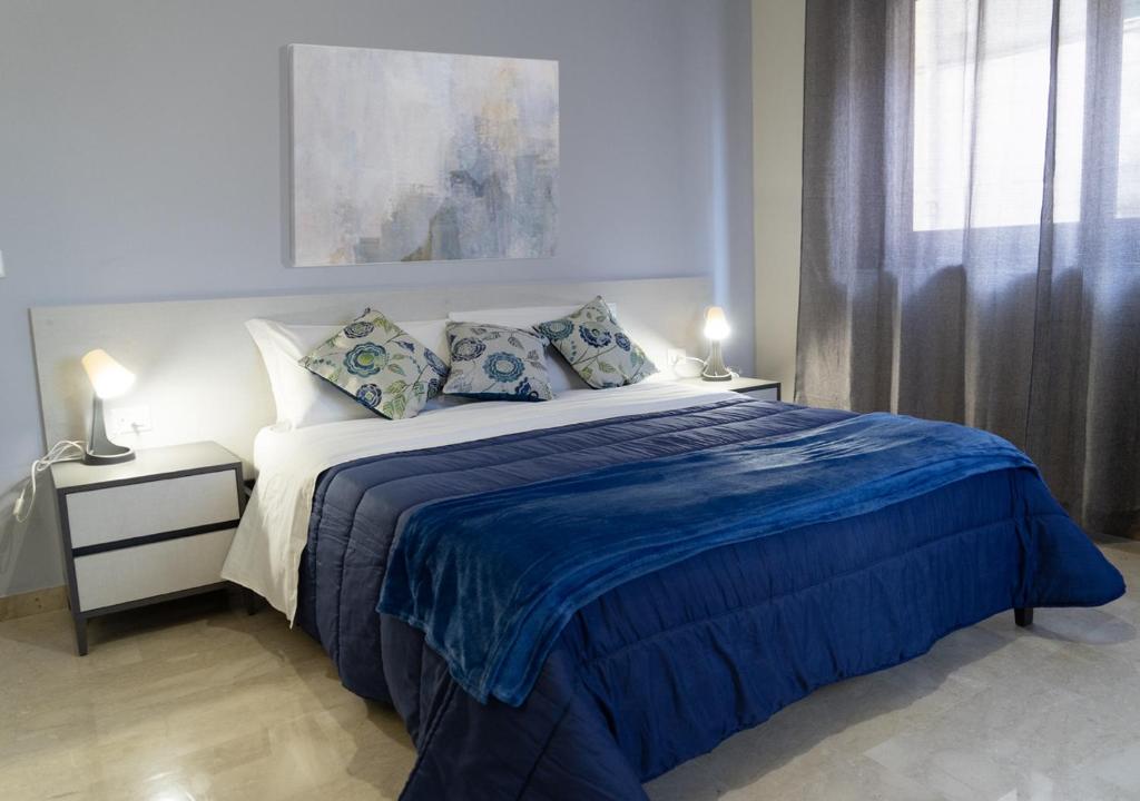 a bedroom with a large bed with blue sheets and pillows at PAPALi 289 in Catania