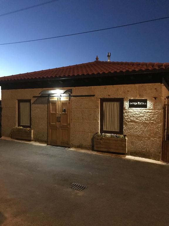 a brick building with a door and a sign on it at Casa Escuela Trasmiras 