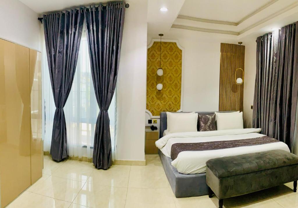 una camera d'albergo con due letti e un divano di De Fivez a Lagos