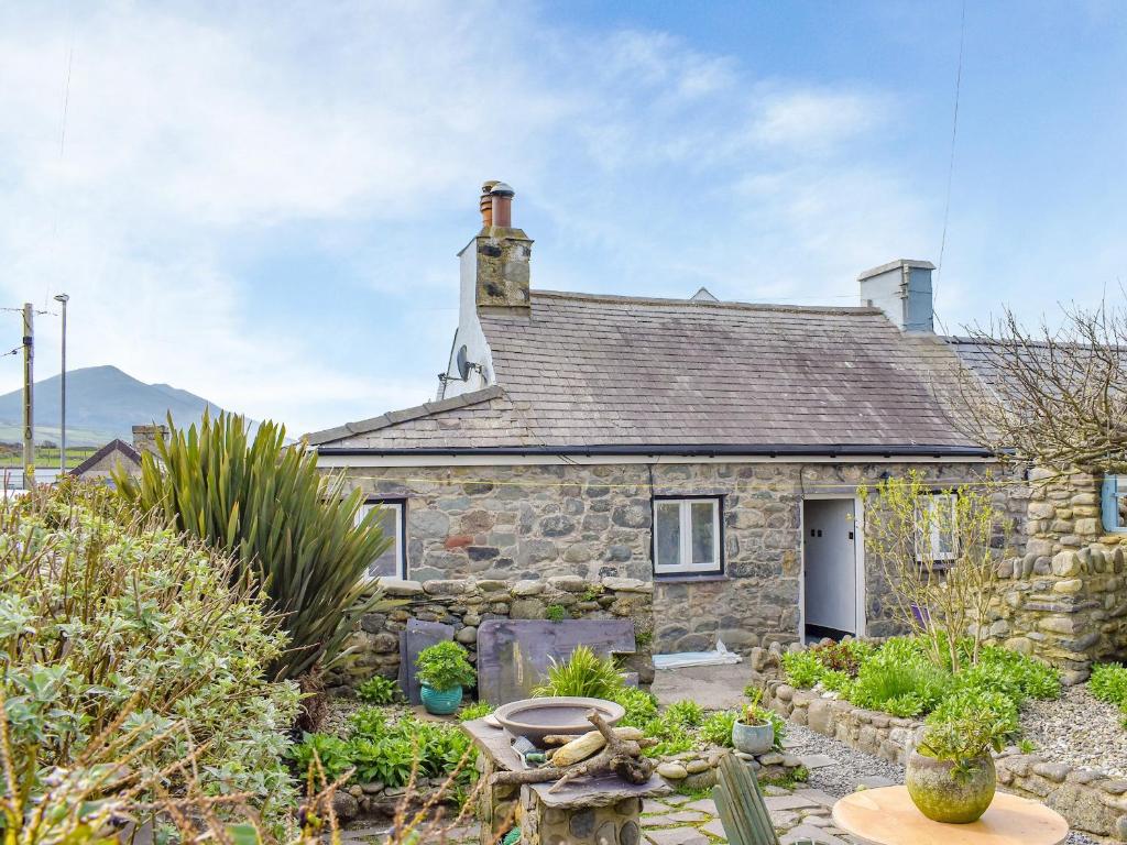 a stone house with a garden in front of it at The Yard Beach Cottage - Uk43653 in Clynnog-fawr