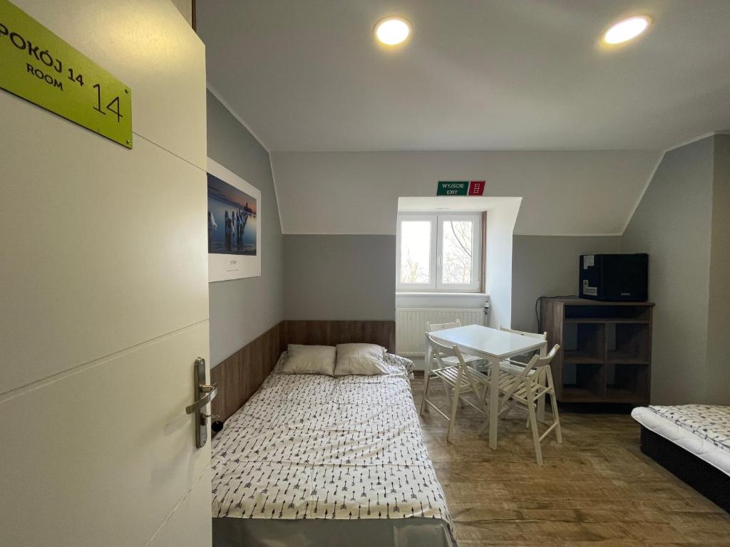 a small room with a bed and a table at BP Hostel Gdynia in Gdynia