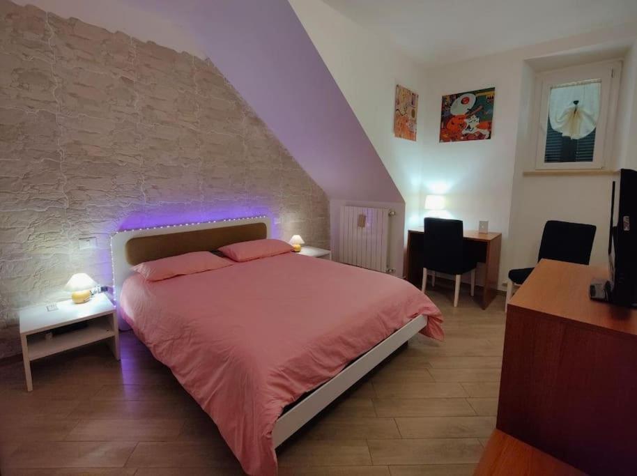 Incantevole Casina di Mara WiFi molto attrezzata في توسكانيا: غرفة نوم بسرير مع اضاءة ارجوانية