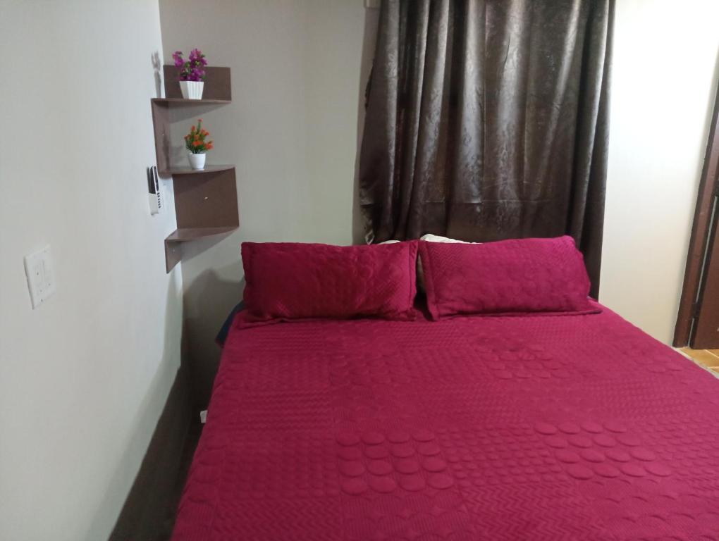 1 cama con sábanas rosas y almohadas en una habitación en Chocolate condo, en San Felipe