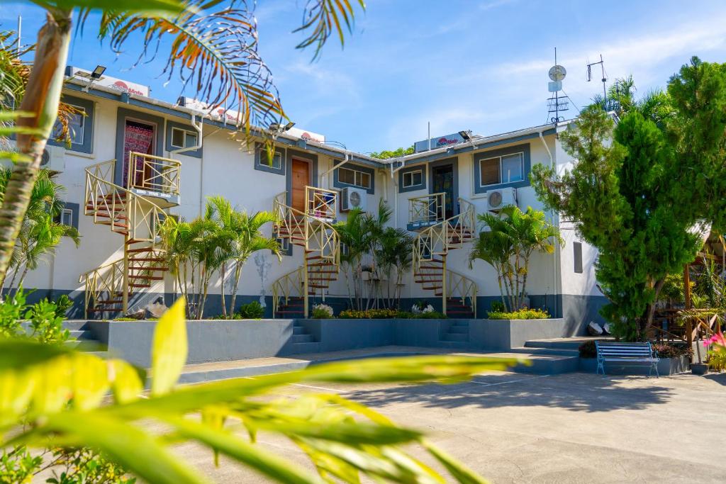 un edificio con palmeras delante en Sanalae Apartments, en Honiara