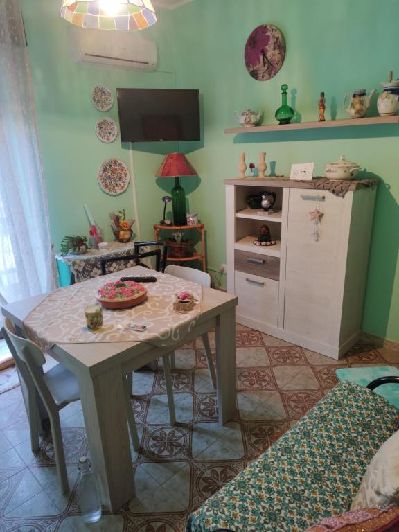 sala de estar con mesa y TV en Cottage Gole Alcantara holiday Pafumi, en Graniti