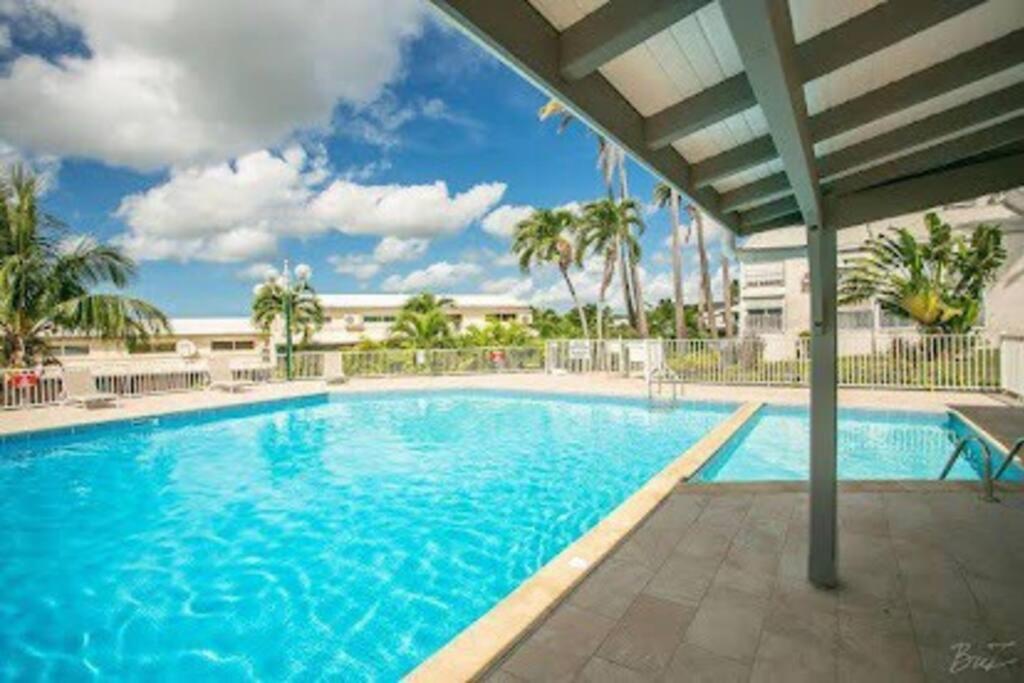 una grande piscina in un resort con palme di Appartement à la marina du Gosier a Le Gosier