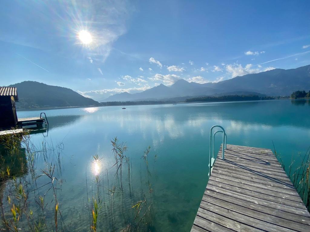 a view of a lake with a wooden dock at Seechalet Faaker See in Drobollach am Faakersee