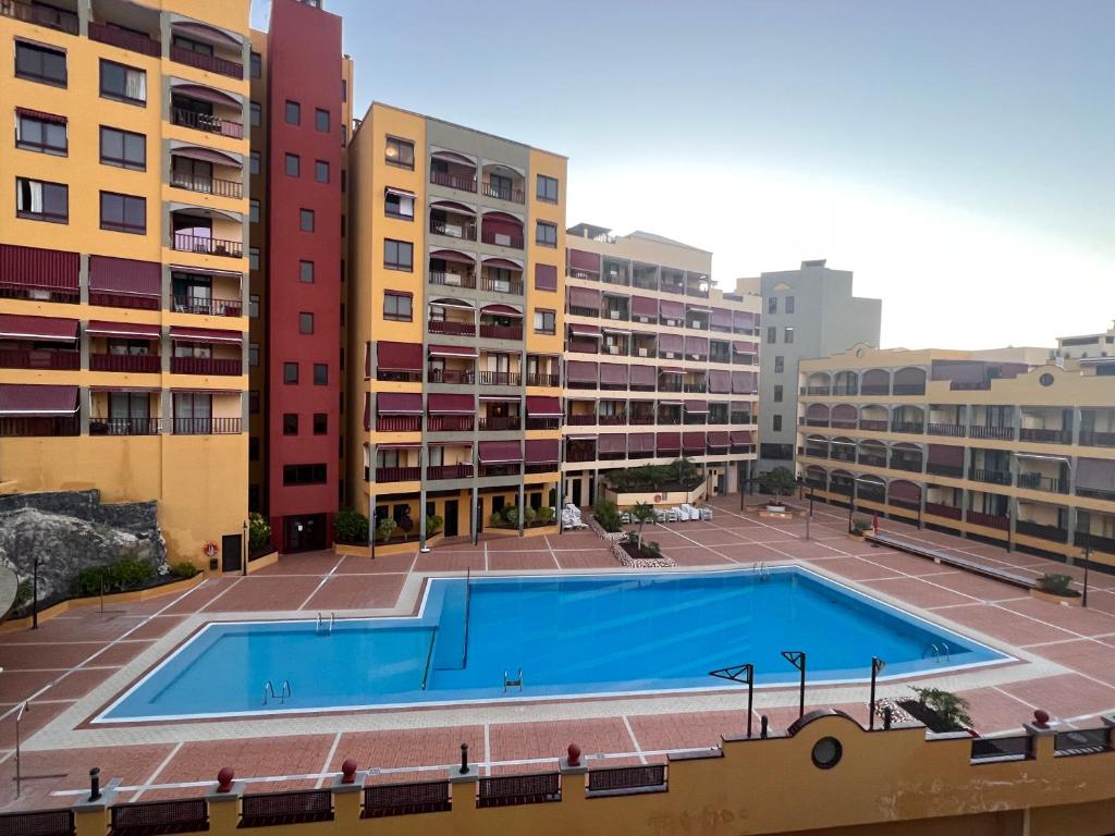an empty swimming pool in front of some buildings at Olivia SunSet Uno in Puerto de Santiago