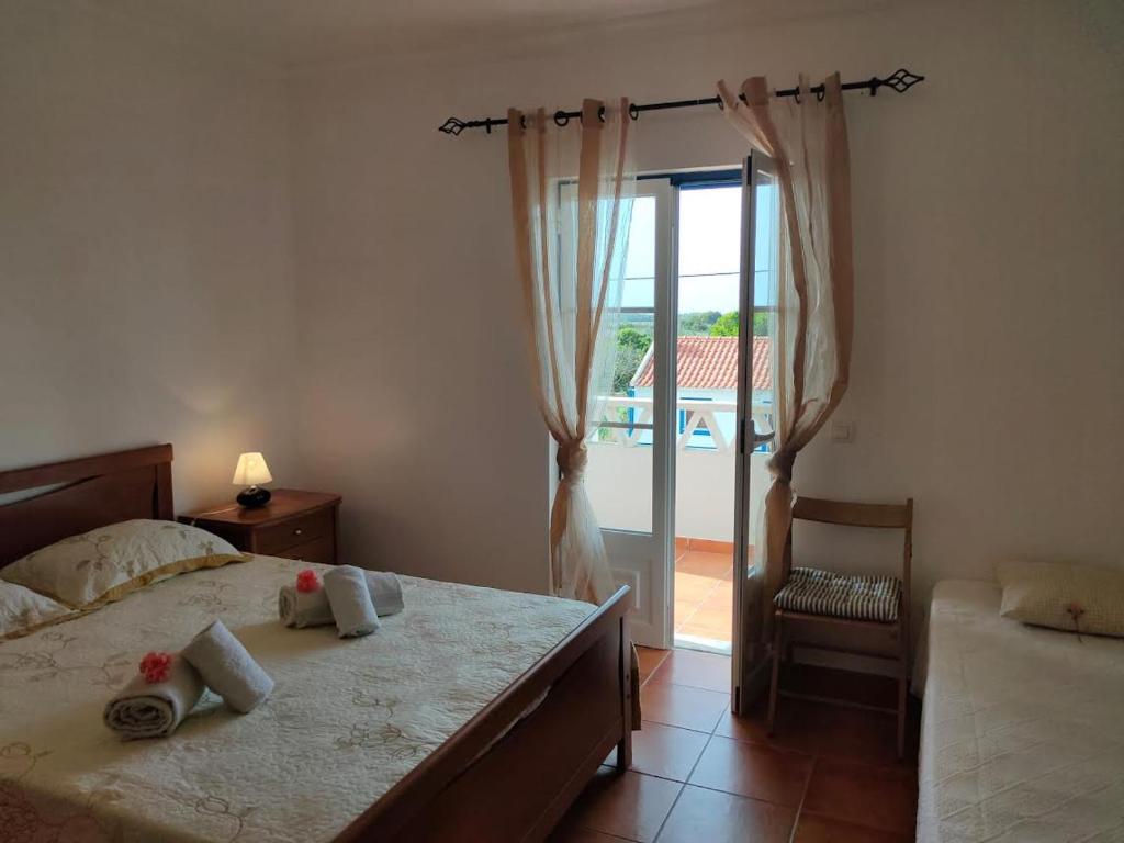 a bedroom with a bed and a sliding glass door at Casa Guerreiro in Longueira