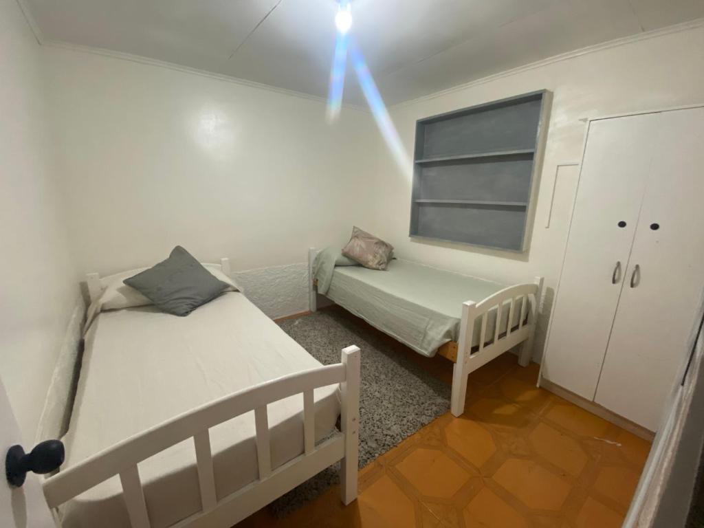 塔尔塔尔Casa Nórdica的一间小房间，里面有两张床和一个窗户。