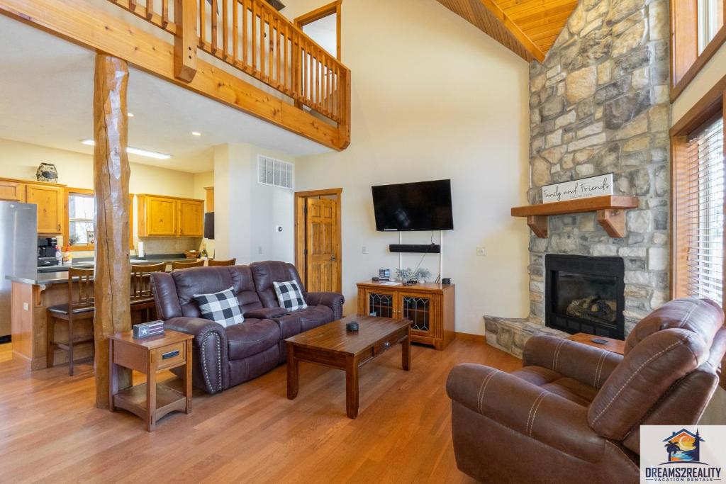 a living room with leather furniture and a stone fireplace at Forest Heights Lodge - 6BR - Pool Table - Near Silver Dollar City - FREE TICKETS INCLUDED in Branson