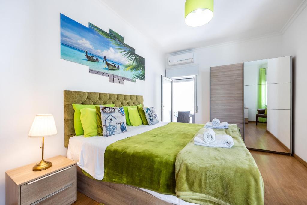 ポルティマンにあるLuxury 3 Bedroom Apartment - Portimãoのベッドルーム1室(大型ベッド1台、緑の毛布付)