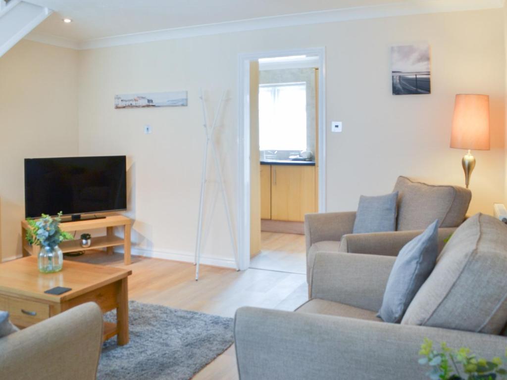 a living room with a couch and a tv at Filey Central Two - Uk42903 in Filey