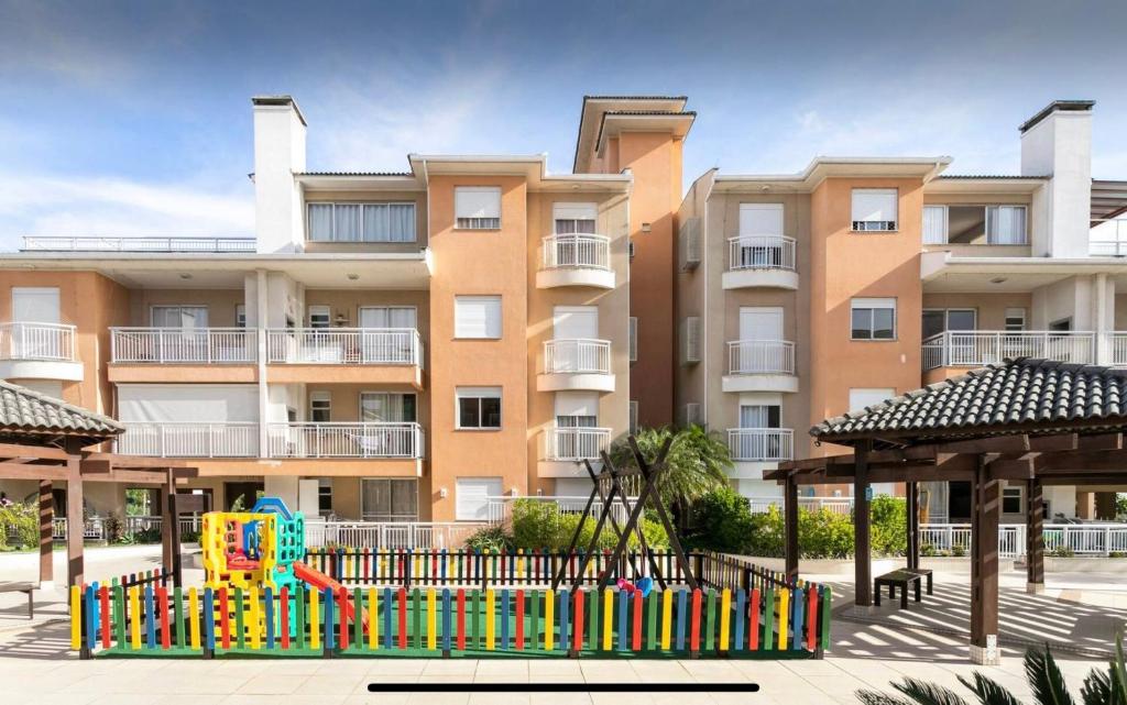 um parque infantil em frente a um edifício de apartamentos em Apartamento Completo nos Ingleses em Florianópolis