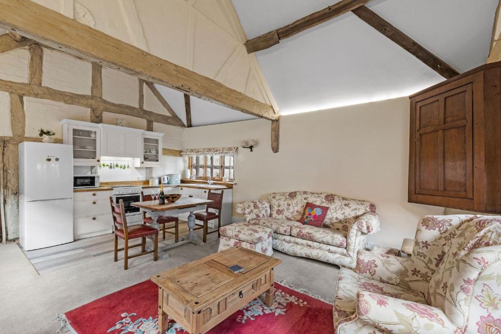 a living room with a couch and a table at Gardeners Cottage near Ledbury in Ledbury