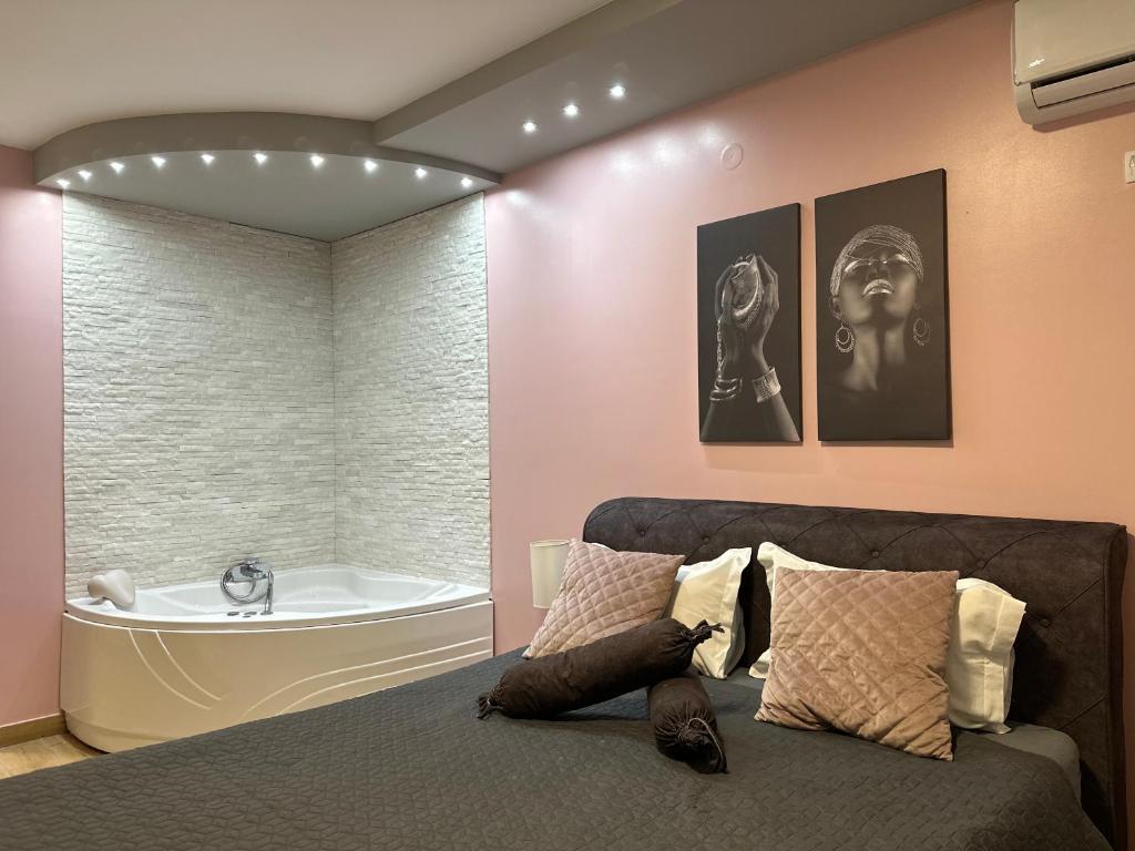 a bedroom with a bed and a bath tub at Room Jacuzzi “ATHENA” in Subotica