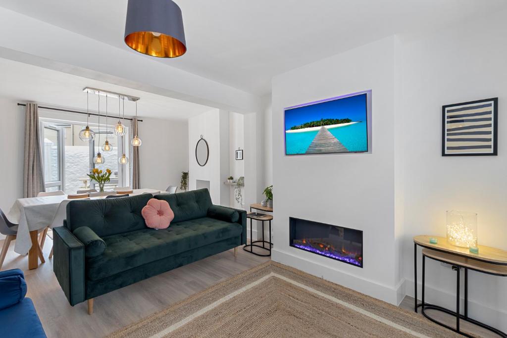 a living room with a green couch and a fireplace at 9 Riverside in Sidmouth