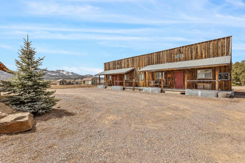 un gran edificio de madera con un árbol delante de él en Trapper's Rendezvous en Williams