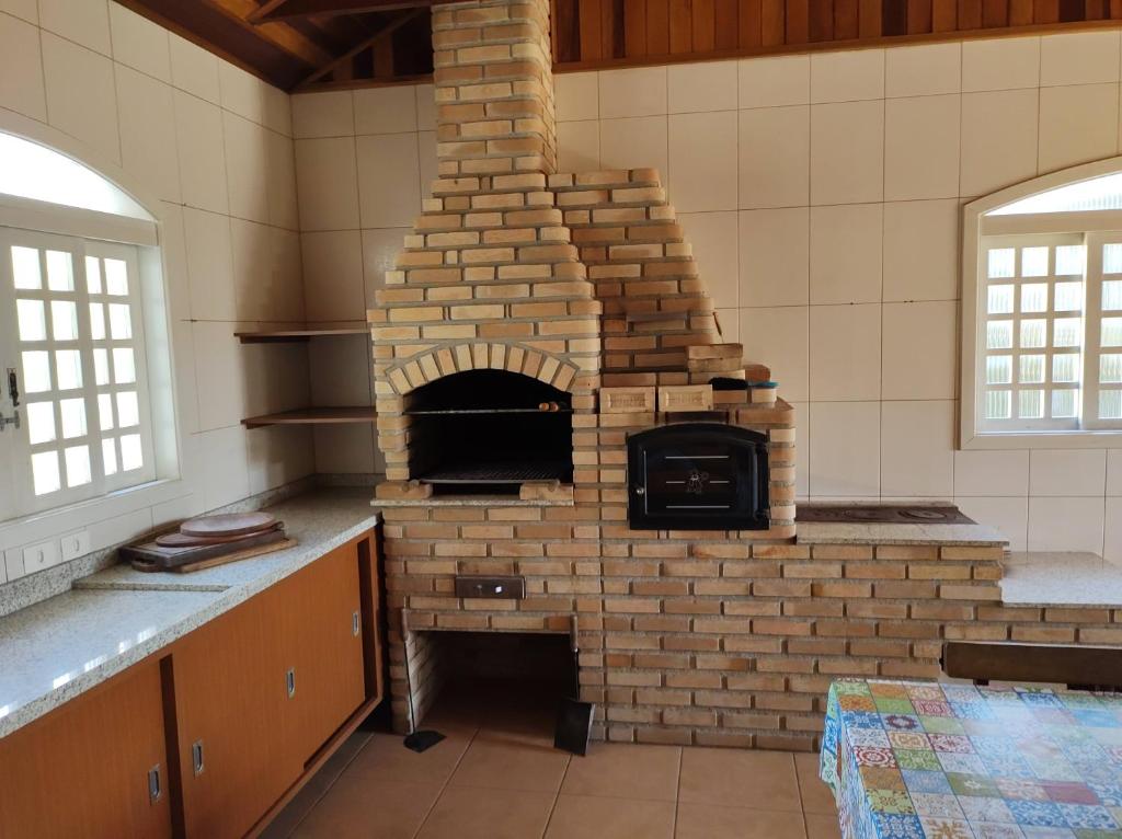 uma cozinha com um forno de tijolos no meio em Casa do Nonno na Montanha em Campos do Jordão