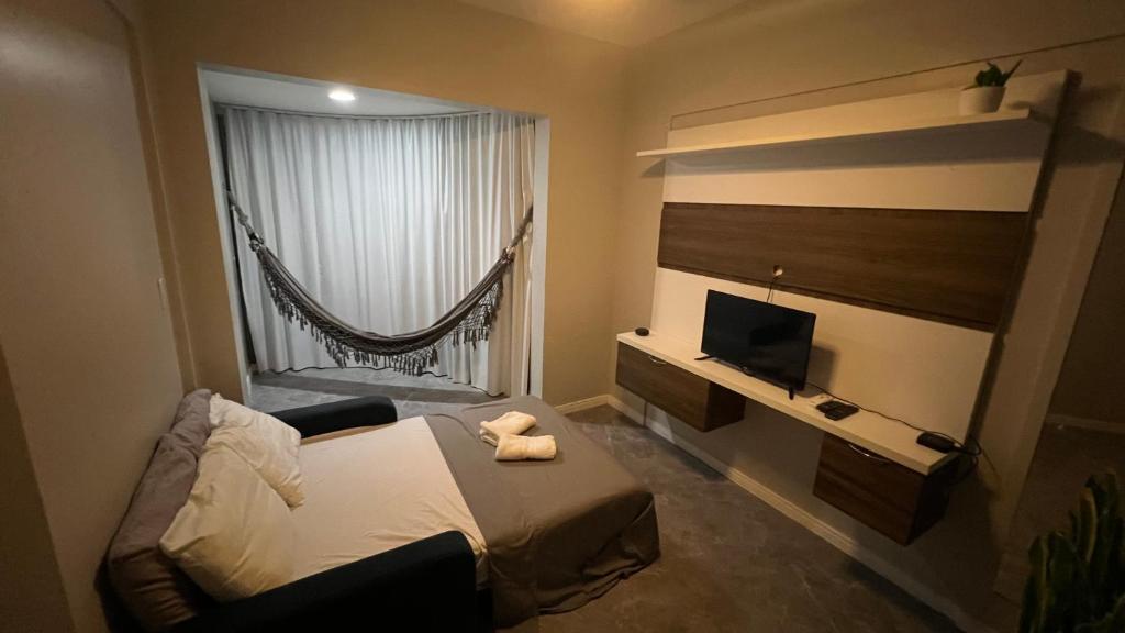 a small bedroom with a bed and a television at Lindo vista mar na Praia do Buracão - Rio Vermelho in Salvador