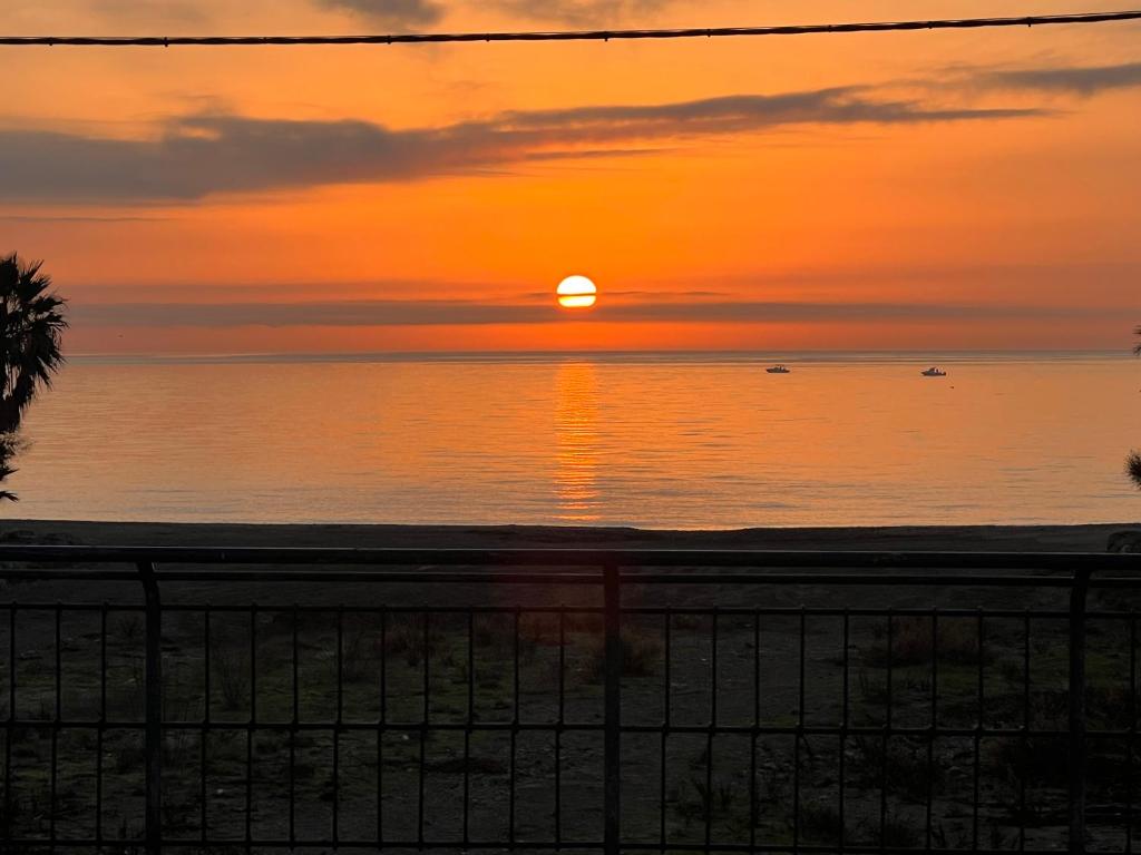 una puesta de sol sobre el océano con la puesta de sol en PLAYALUZ, en Aguadulce