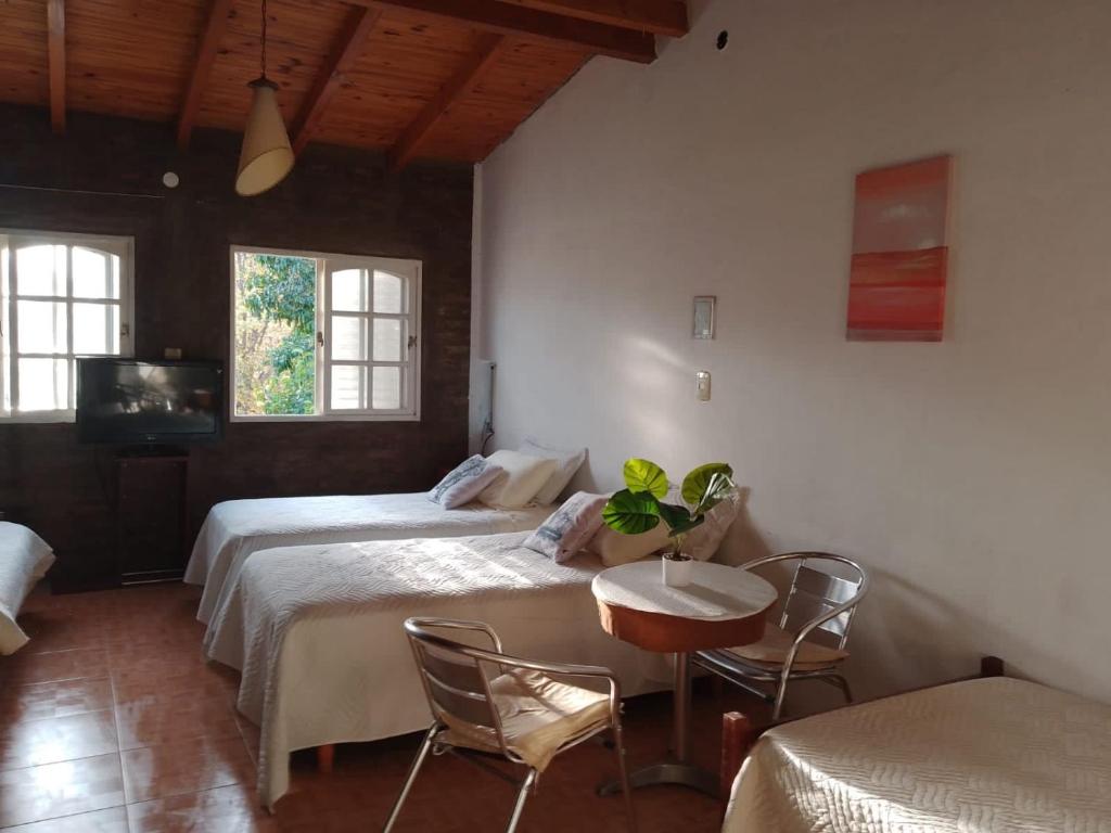 1 dormitorio con 2 camas, mesa y sillas en El Parralito en Luján de Cuyo