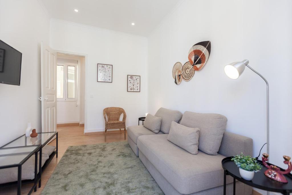 een witte woonkamer met een bank en een tafel bij FLH Penha França Peaceful Flat in Lissabon