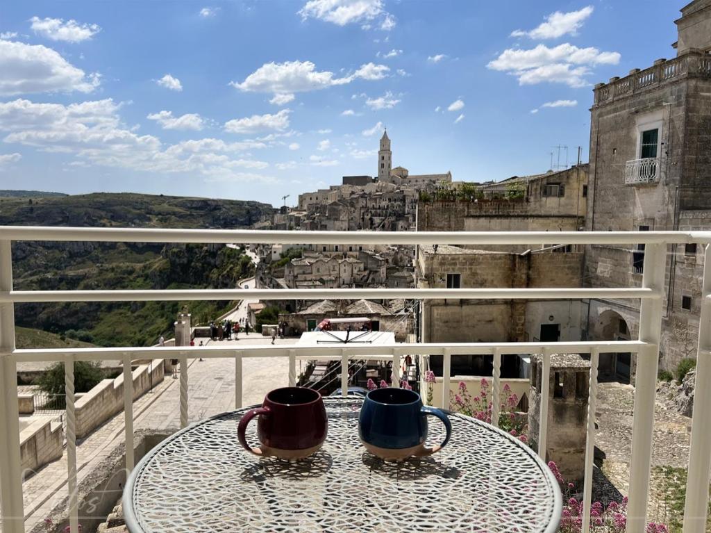 duas canecas sentadas numa mesa numa varanda em LA DIMORA DI ANTOSA em Matera