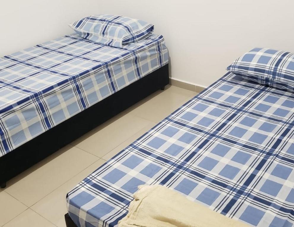 Duas camas sentadas uma ao lado da outra num quarto em Apartamento Aparecida do norte em Aparecida