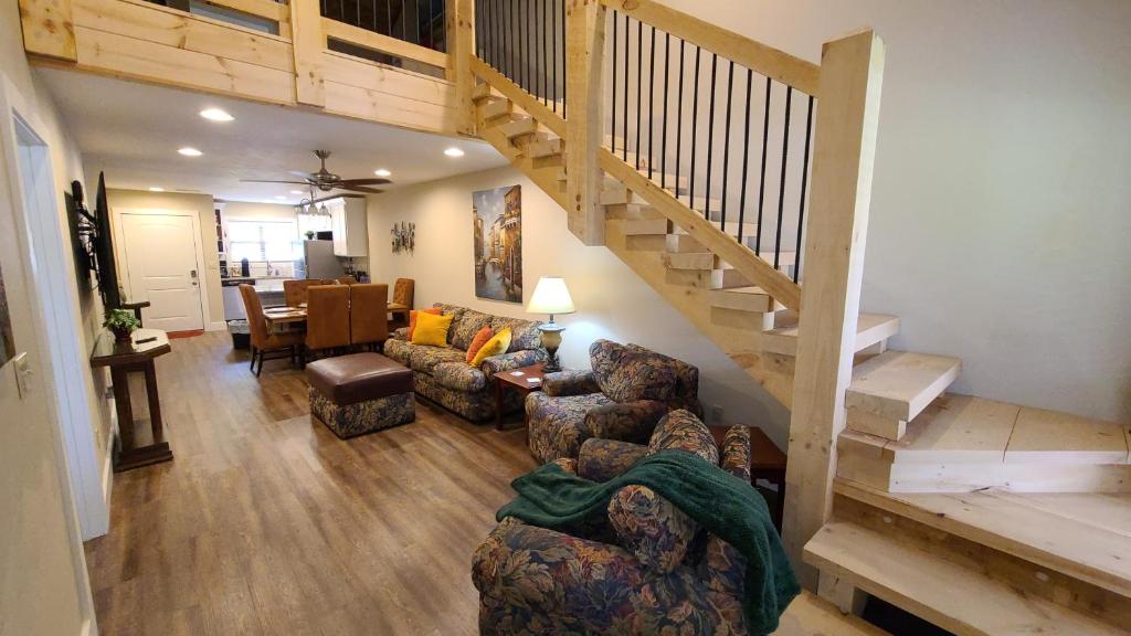 a living room with a staircase and a couch and chairs at 3BR Walk-In with Loft - Pool and Hot Tub - FREE ATTRACTION TICKETS INCLUDED - PARA in Branson
