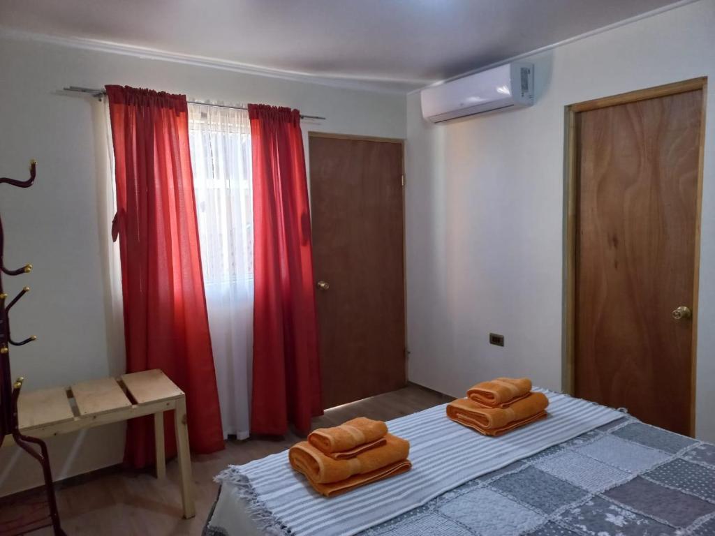 1 dormitorio con 1 cama con 2 almohadas marrones en hostal casa talitha en San Pedro de Atacama