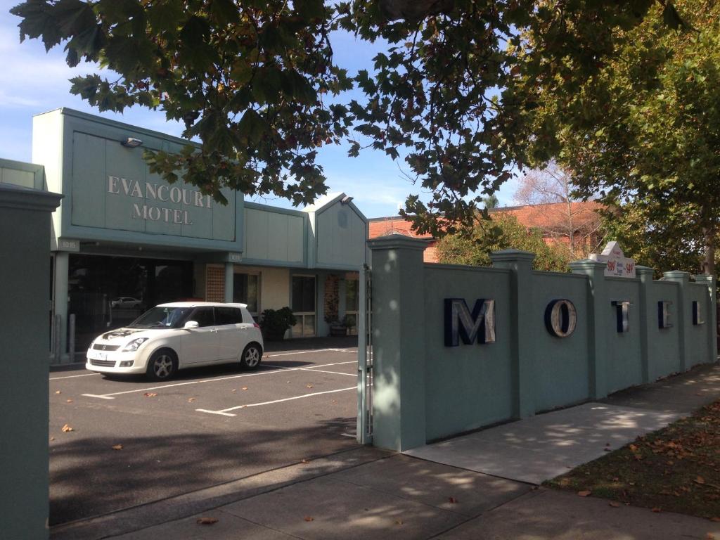 a white car parked in a parking lot next to a building at Evancourt Motel Malvern East in Melbourne