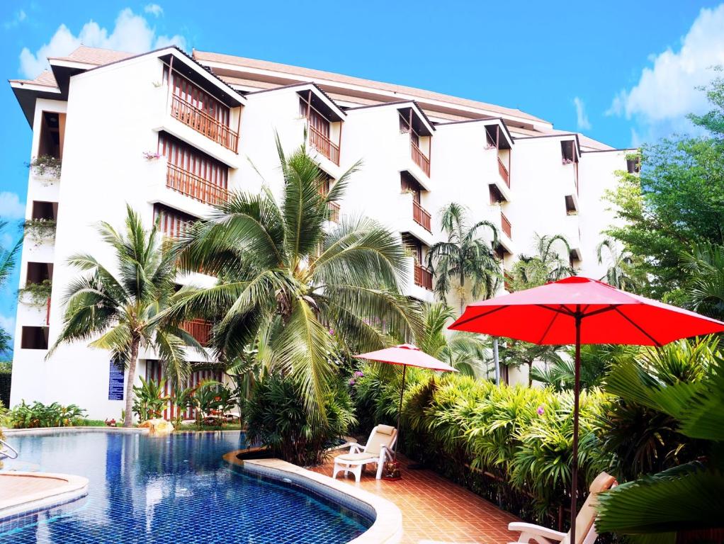 un hotel con piscina y sombrilla roja en The Oriental Tropical Beach at VIP Resort, en Ban Phe