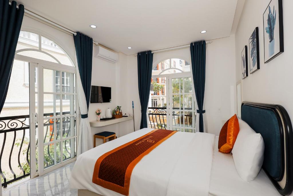 a bedroom with a large bed and a balcony at Hai Duong PQ Hotel in Phu Quoc