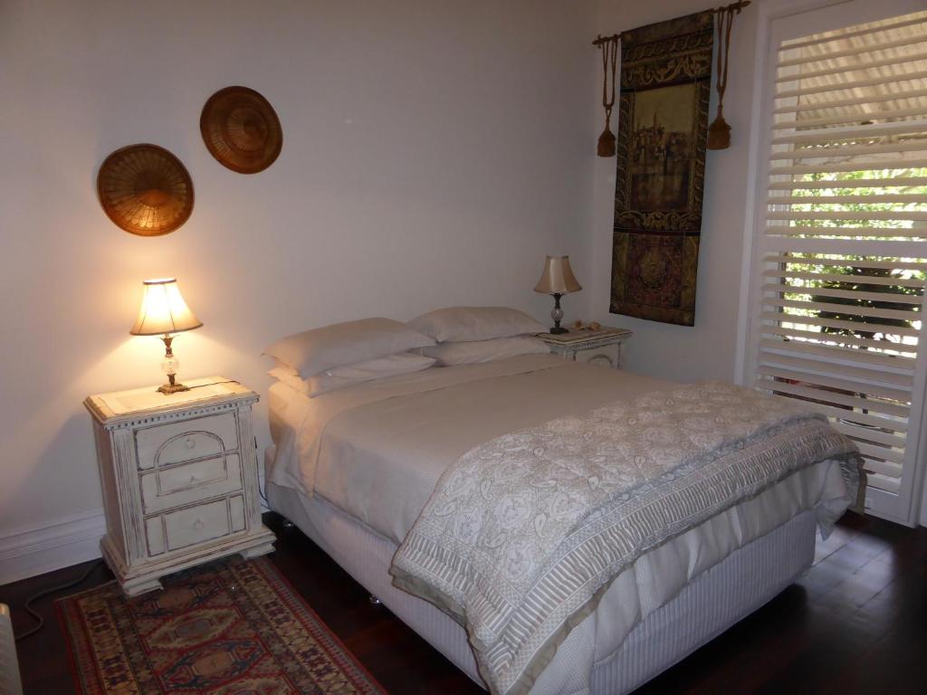 ein Schlafzimmer mit einem Bett, einem Nachttisch und einem Fenster in der Unterkunft Lakeside Bed & Breakfast in Perth