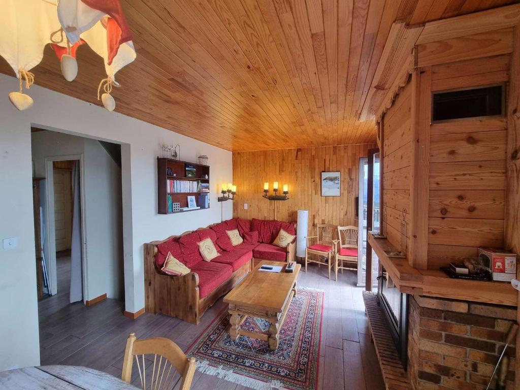 a living room with a red couch and a table at Chalet Saint-Michel-de-Chaillol, 5 pièces, 9 personnes - FR-1-393-168 in Saint-Michel-de-Chaillol