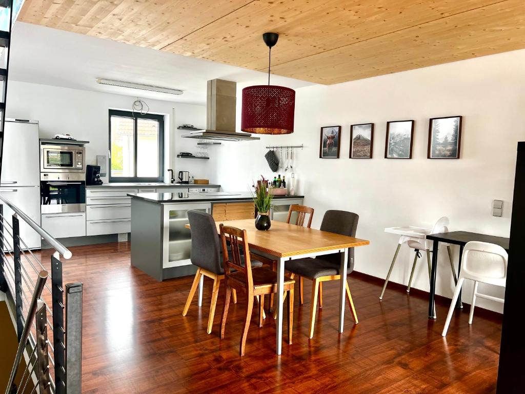 een keuken en eetkamer met een houten tafel en stoelen bij MoPa - Stylisch wohnen zwischen Alb und Legoland in Leipheim