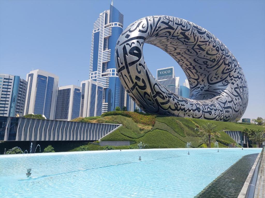 eine große Skulptur vor einem Pool in einer Stadt in der Unterkunft Sunrise Dubai in Dubai