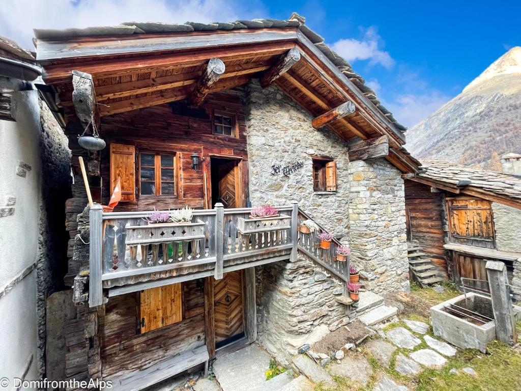 ein Holzhaus mit einem Balkon an der Seite in der Unterkunft Haus Zer Trächu in Saas-Almagell