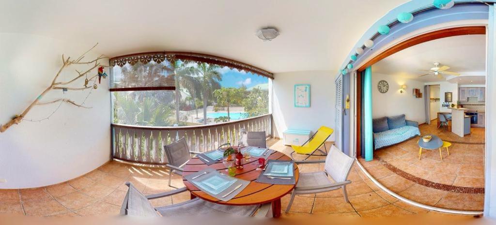 uma sala de estar com mesa e cadeiras em Seadream Paradise appartement vue piscine à 150m de la plage em Saint Martin