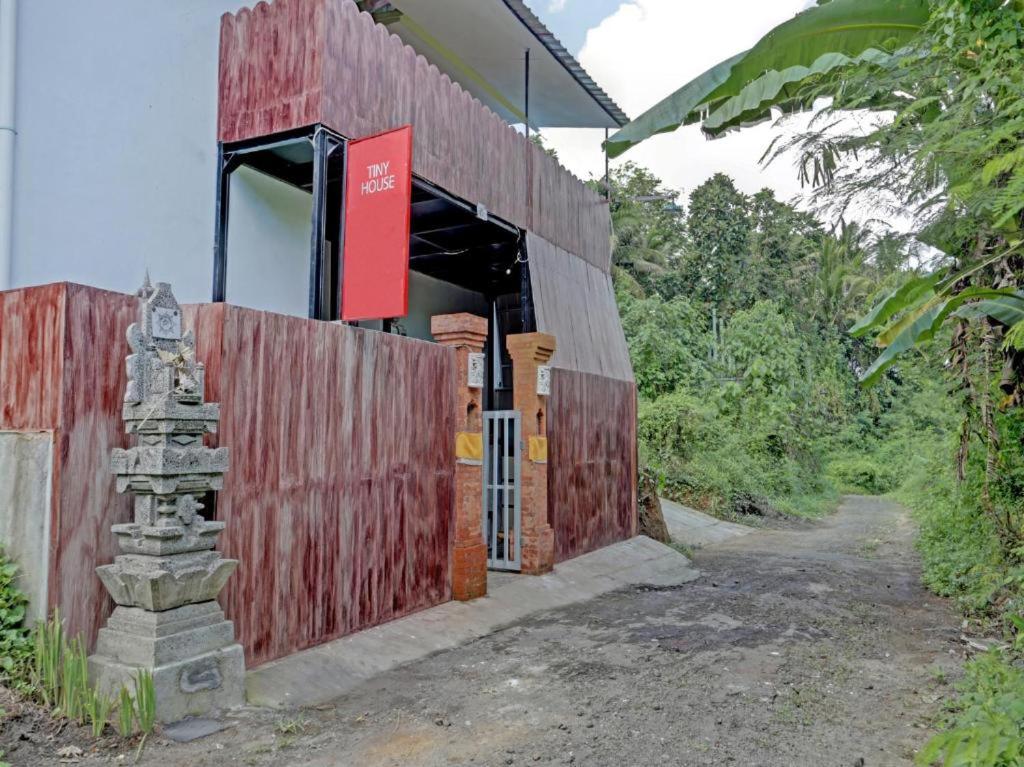 um edifício de madeira vermelha com um sinal vermelho em Tiny House Gianyar em Gianyar